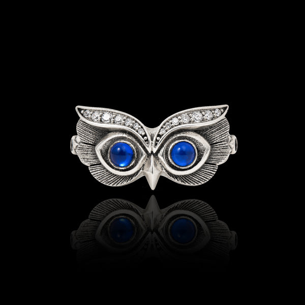 PurpleSea Owl Ring, sterling silver owl ring with vivid blue round eyes and detailed feather engraving, front product view on a black background