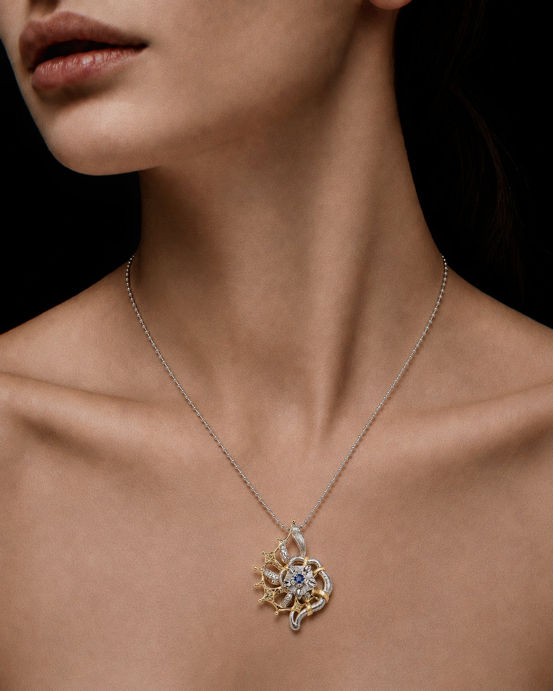 PurpleSea Reborn Conch Pendant, sterling silver conch-inspired pendant with gold shell details, flowing sculptural lines and a blue center stone, shown worn as a necklace on a model