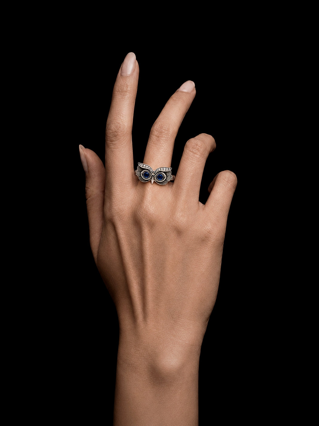 PurpleSea Owl Ring, sterling silver owl ring with vivid blue round eyes and detailed feather engraving, shown worn on a model's hand