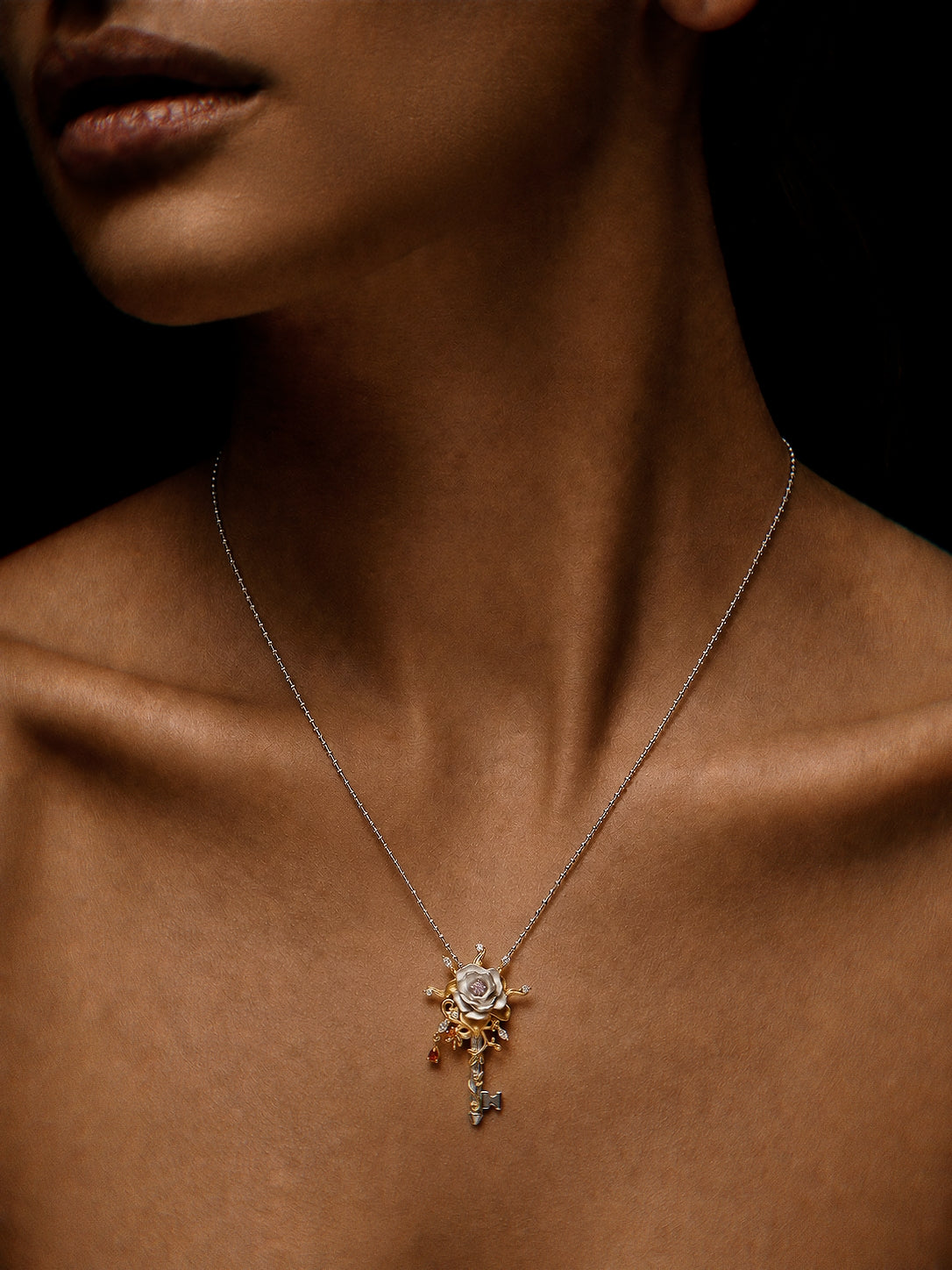 PurpleSea Hierophant Rose Pendant, sterling silver rose pendant with gold rays, red accents and a dangling key-like detail, shown worn as a necklace on a model