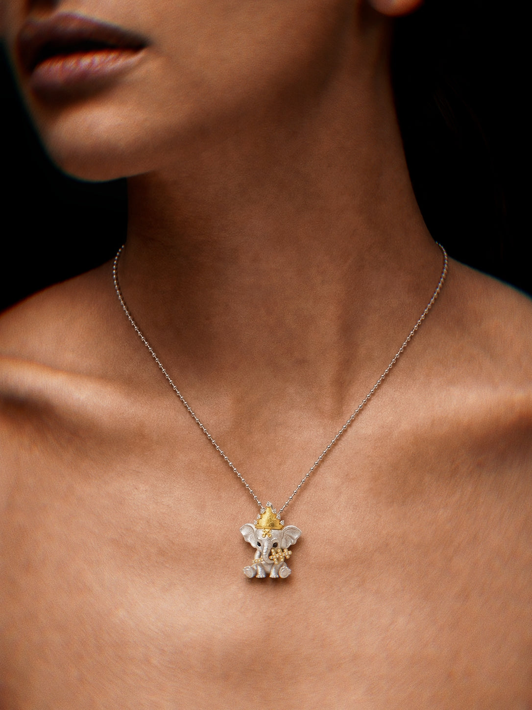 PurpleSea Hierophant Elephant Pendant, sterling silver elephant pendant with a gold crown, blue stone eyes and ornate gold details, shown worn as a necklace on a model